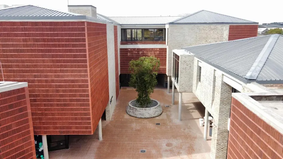 Inner courtyard with a planted tree between the brick and stone blocks