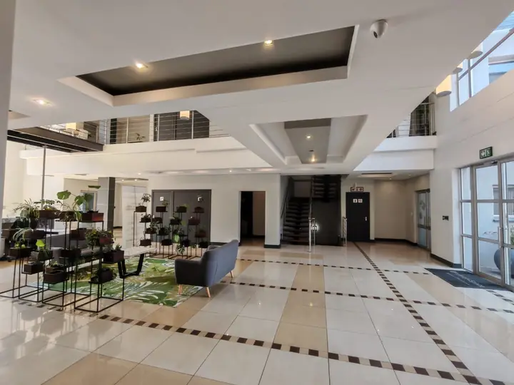Lobby with plant stands and tiled floor at Corporate Park 66