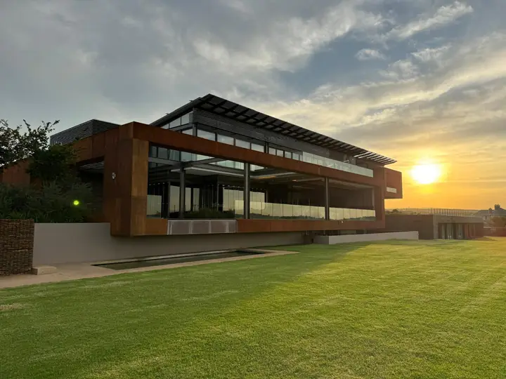 Contemporary Mooikloof home at sunset: rust-toned cladding and deep overhangs