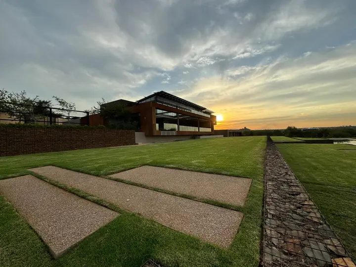 Sunset over the lawn and paving at the Mooikloof residence